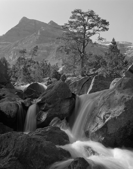 Photo 7. Almost vertical lines and moving water concurs with stable triangular shape of a mountain on the far plane, thus well expressing the usual alpine atmosphere.