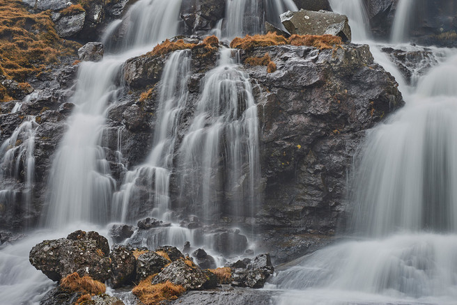 Close-up of one of many waterfalls around Fuglafjørður, shot from the back seat of the car.