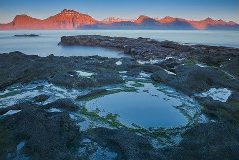 The setting sun illuminates the chain of mountains of the island of Kalsoy. [14 Gjógv Minimalism] Pastel colours at dusk. 