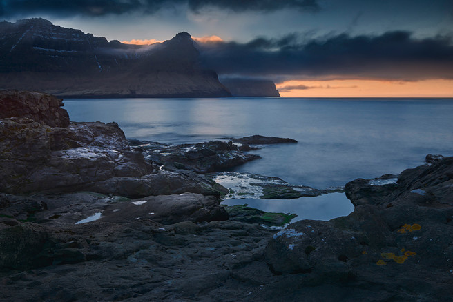 The island of Kunoy seen from the rocky shore of Viðareiði at the last light of the day.